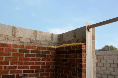Enerji tasarrufu önlemlerinin bir parçası olarak duvar boşluklarının içine kaya yünü koyarak yeni inşa edilen evin duvarlarını izole etmek