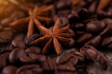 Çikolata, tarçın çubukları ve ahşap arka planda kahve çekirdekleri.