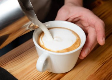 barista kahve bir fincan süt dökme