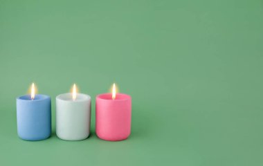 Metin için yeşil arkaplanda üç renkli mum