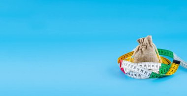 Mavi arkaplan üzerinde bir santimetre olan küçük bir bez çanta.