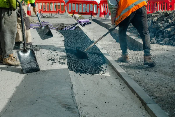 Construction Workers Placing Hot Tarmac Installation New Underground Services Kerbs — Stock Photo, Image