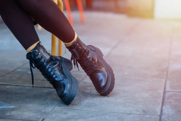 feet of a woman in a black shoes  on the city street on cold day