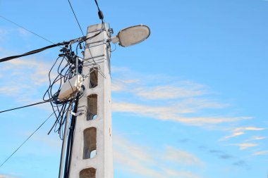 Bulutlu mavi gökyüzü arka planında bir sürü kablo bulunan sokak lambası direği. Metin için yeri var. Enerji dağılımı kavramı