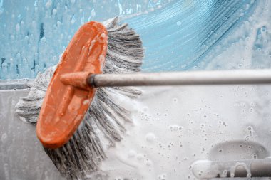 Açık havada bir jet yıkama ile temizlemeden önce bir arabayı fırça ve sabunla yıkarken çekilmiş yakın plan bir fotoğraf. Temizlik ve dezenfeksiyon. Salgın sırasında güvenlik önlemleri