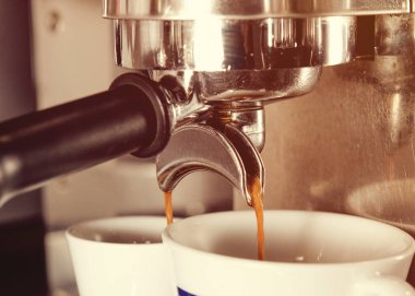 Kahve doldurmadan önce kahve makinesinde bir fincan kahve. Kahveci kafede kahve yapıyor.