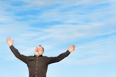 Siyahlı Mutlu Adam mavi kurnazlığa karşı ellerini kaldırıyor.