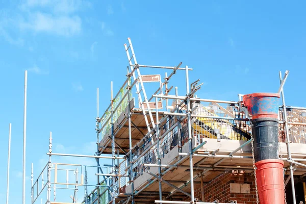 Scaffold installed around houses to provide access for bricklayers and other trades on construction site