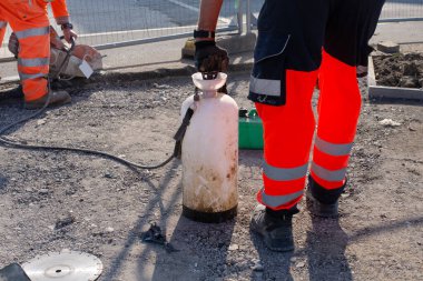 Saha çalışanı, asfaltı benzin testeresiyle kesiyor.