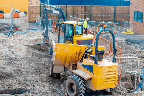 İnşaat fabrikası ve makineler. Çöplük ve kazıcı yeni evler inşaatında çalışıyor.