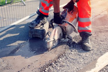 Saha işçisi, benzin testeresiyle yol kesiyor.