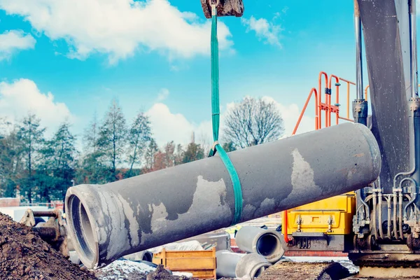 İnşaat alanındaki drenaj çalışmaları sırasında kazıcı tarafından kaldırılan beton drenaj borusu.
