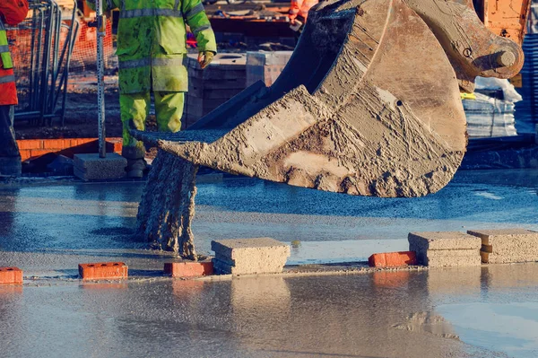 Pouring ready-mixed concrete by excavator