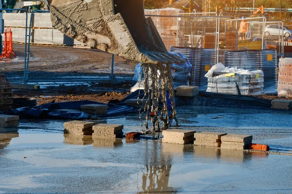 Pouring ready-mixed concrete by excavator