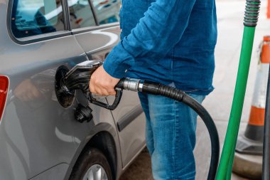 A man at the gas station filling the tank of his car with diesel to the top level before a long journey as fuel prices is going up