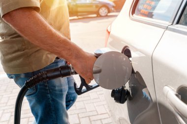 A man at the gas station filling the tank of his car with diesel to the top level before a long journey as fuel prices is going up