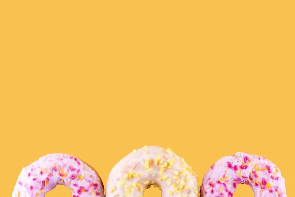 Рожеві Жовті Пряді Пончики Жовтому Фоні Простір Тексту Високоякісні Фотографії — стокове фото