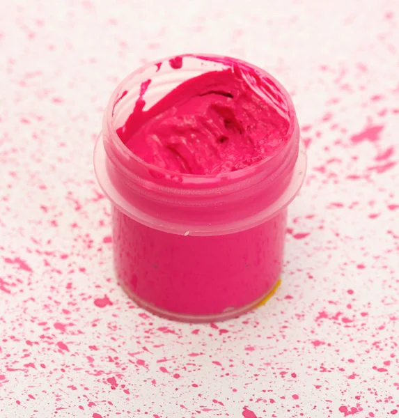 Jar met roze gouache op achtergrond van roze spray close-up — Stockfoto