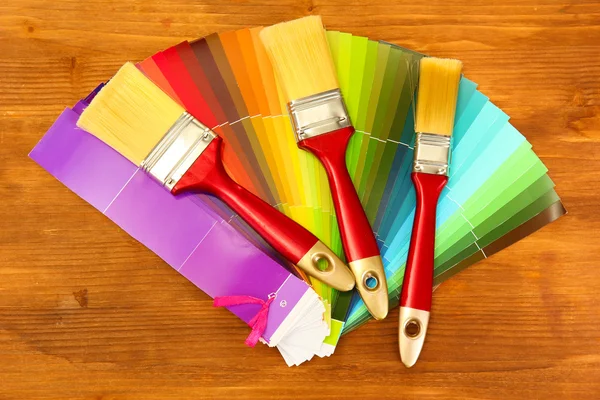 Pincéis de pintura e paleta brilhante de cores sobre fundo de madeira — Fotografia de Stock