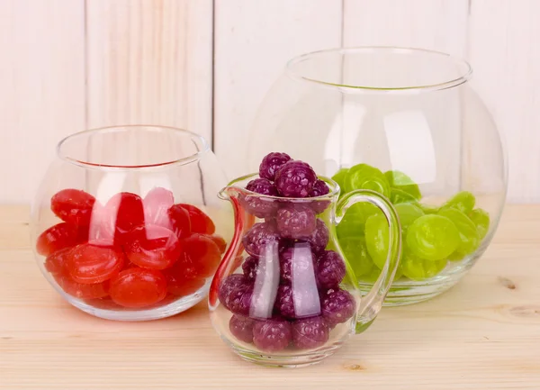 Color candies in glasses on wooden background — Stock Photo, Image