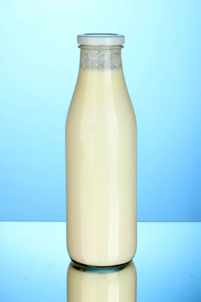 Flasche Milch auf blauem Hintergrund Nahaufnahme — Stockfoto