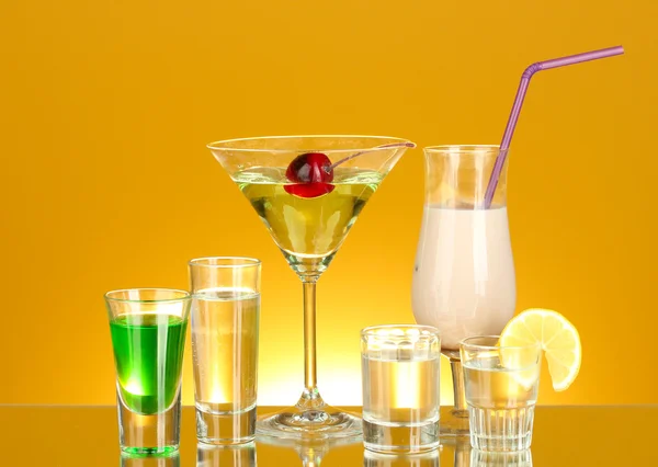 Una variedad de bebidas alcohólicas sobre fondo amarillo — Foto de Stock