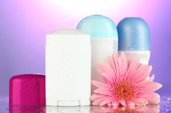 Deodorant Flaschen mit Blume auf lila Hintergrund — Stockfoto