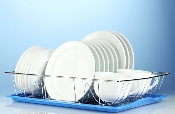 Clean dishes on stand on blue background — Stock Photo, Image