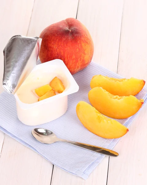 Yogurt with peach on wooden background — Stock Photo, Image