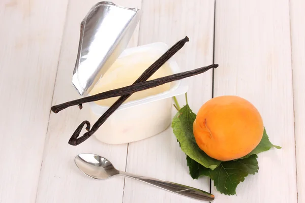 Yogurt with apricot and vanilla on wooden background — Stock Photo, Image