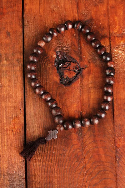 Les perles du chapelet en bois sur le fond en bois close-up — Photo