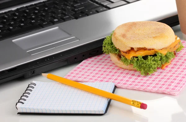 Mangiare sul posto di lavoro vicino laptop — Foto Stock