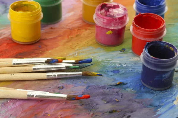 Wooden art palette with paint and brushes, close up — Stock Photo, Image