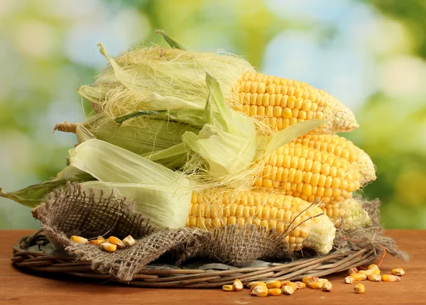 Verse maïs, op houten tafel, op groene achtergrond — Stockfoto