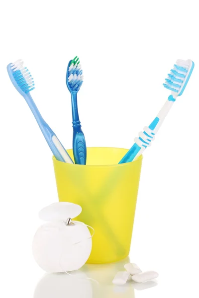 Cepillos de dientes, goma de mascar y hilo dental aislados en blanco — Foto de Stock