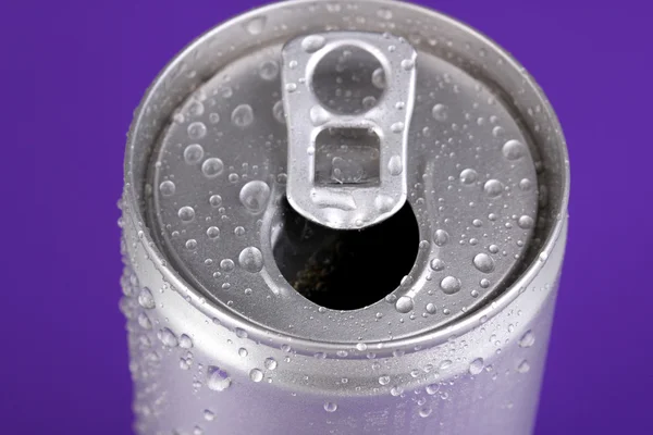 Lattina di alluminio con gocce d'acqua su sfondo viola — Foto Stock