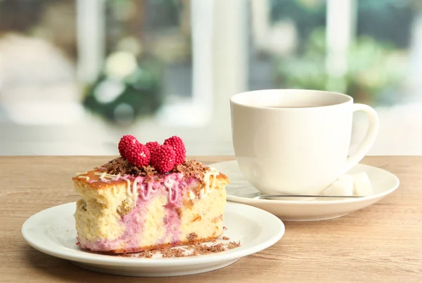 Zoete cake met kopje thee op houten tafel — Stockfoto