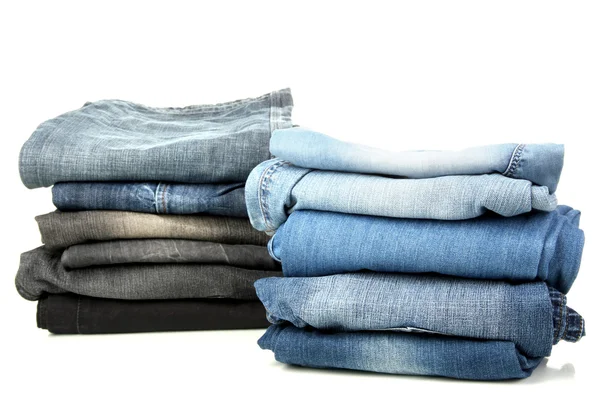 Two stacks of different jeans isolated on white — Stock Photo, Image