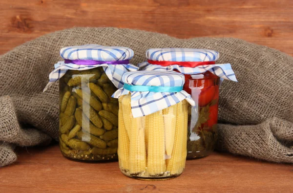 Jars with canned vegetables on wooden background close-up — Stock Photo, Image