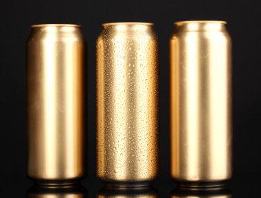 Gouden blikjes met water drops geïsoleerd op zwart