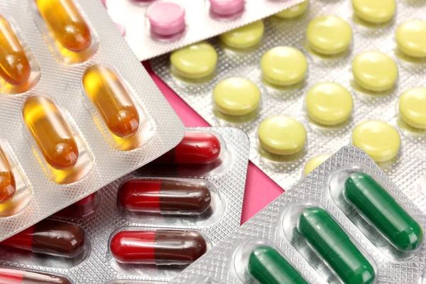 Kapszulák és tabletták csomagolják buborékfóliában, közelről — Stock Fotó