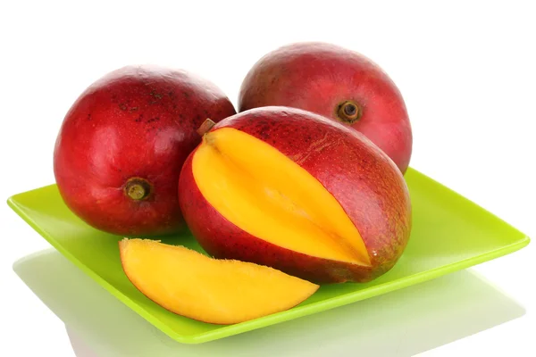 Reife appetitliche Mango auf grünem Teller isoliert auf weißem — Stockfoto