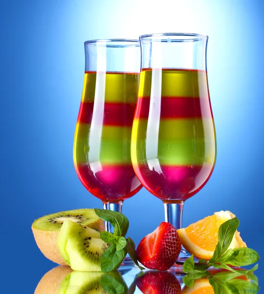 Ovocné želé na brýle a ovoce na modrém pozadí — Stock fotografie