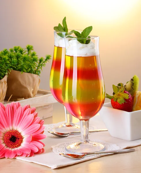 Fruit jelly in glasses and fruits on table in cafe — Stock Photo, Image