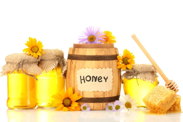 Zoete honing in potten en vat met honingraat, houten drizzler en bloemen — Stockfoto