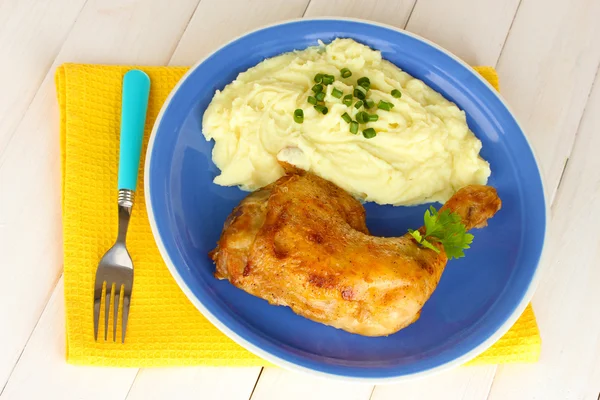 Cuisse de poulet rôtie avec purée de pommes de terre dans l'assiette sur table en bois blanc c — Photo