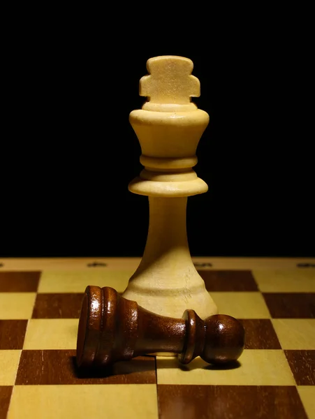 Sjakkbrett med sjakkbrikker isolert i svart – stockfoto