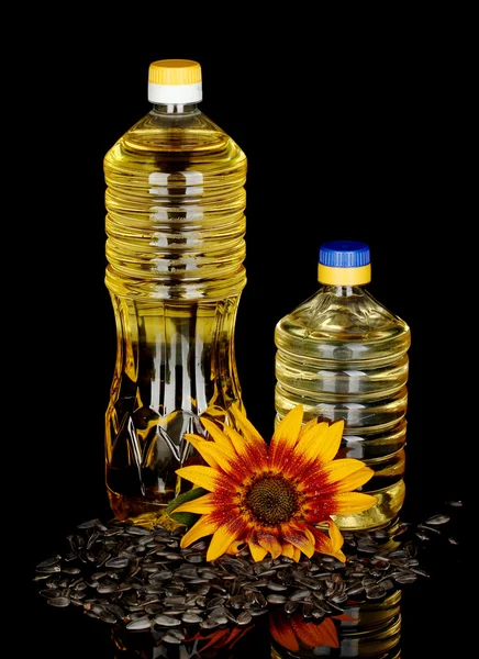 Подсолнечное масло в пластиковых бутылках изолированы на черном фоне — стоковое фото