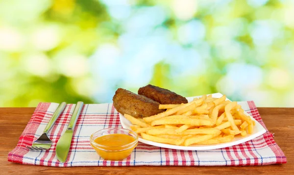 土豆炸薯条和汉堡铭牌上绿色背景特写 — 图库照片