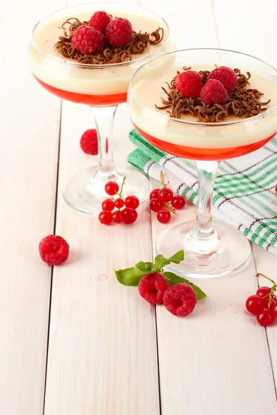 Fruit gelei met bessen in bril op houten tafel — Stockfoto